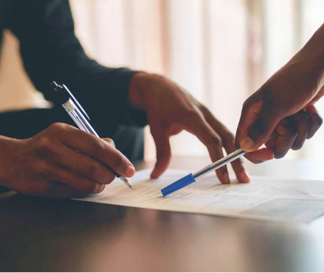 Close-up of hands with pens signing