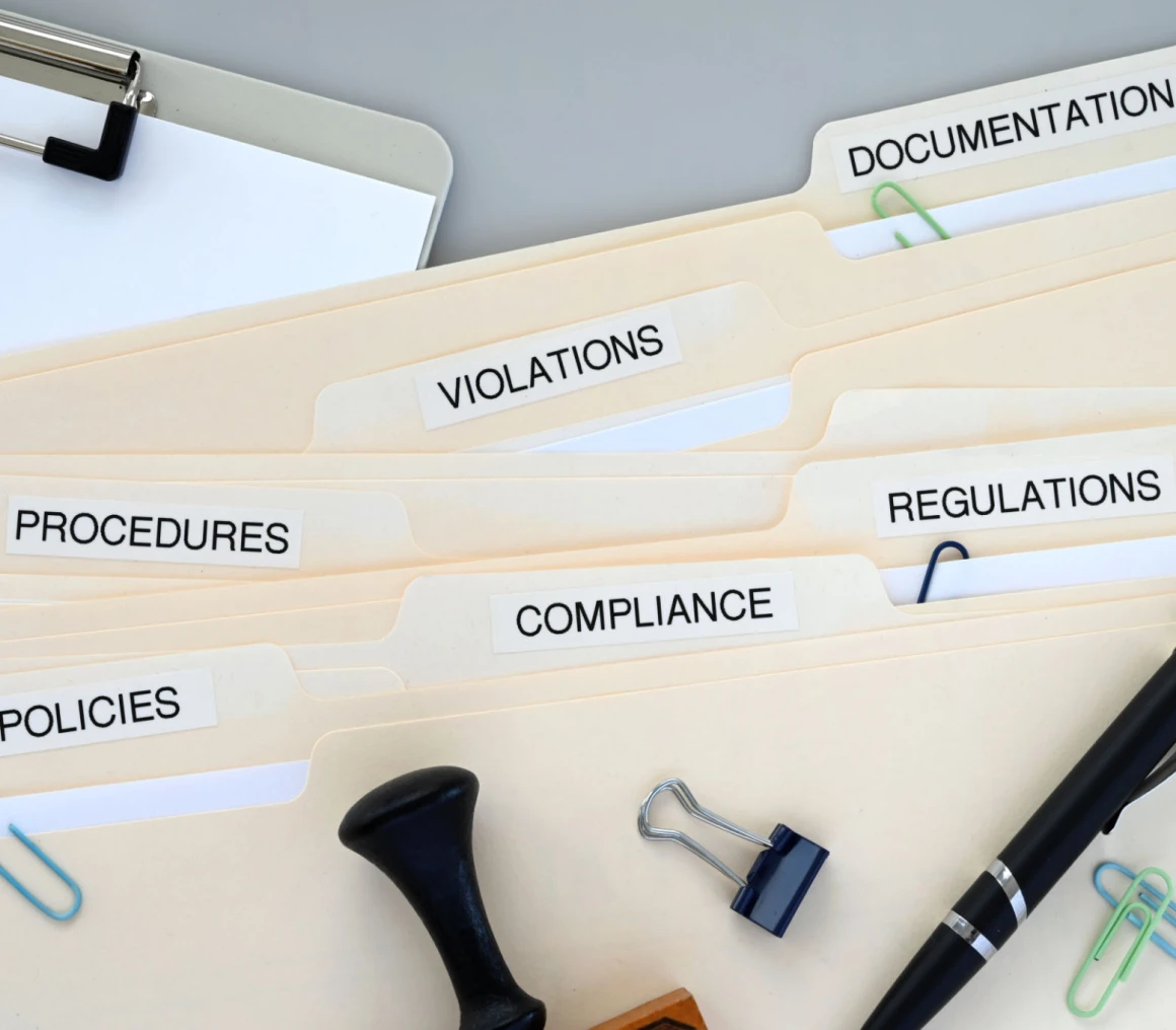 Office folders labeled for compliance and procedures